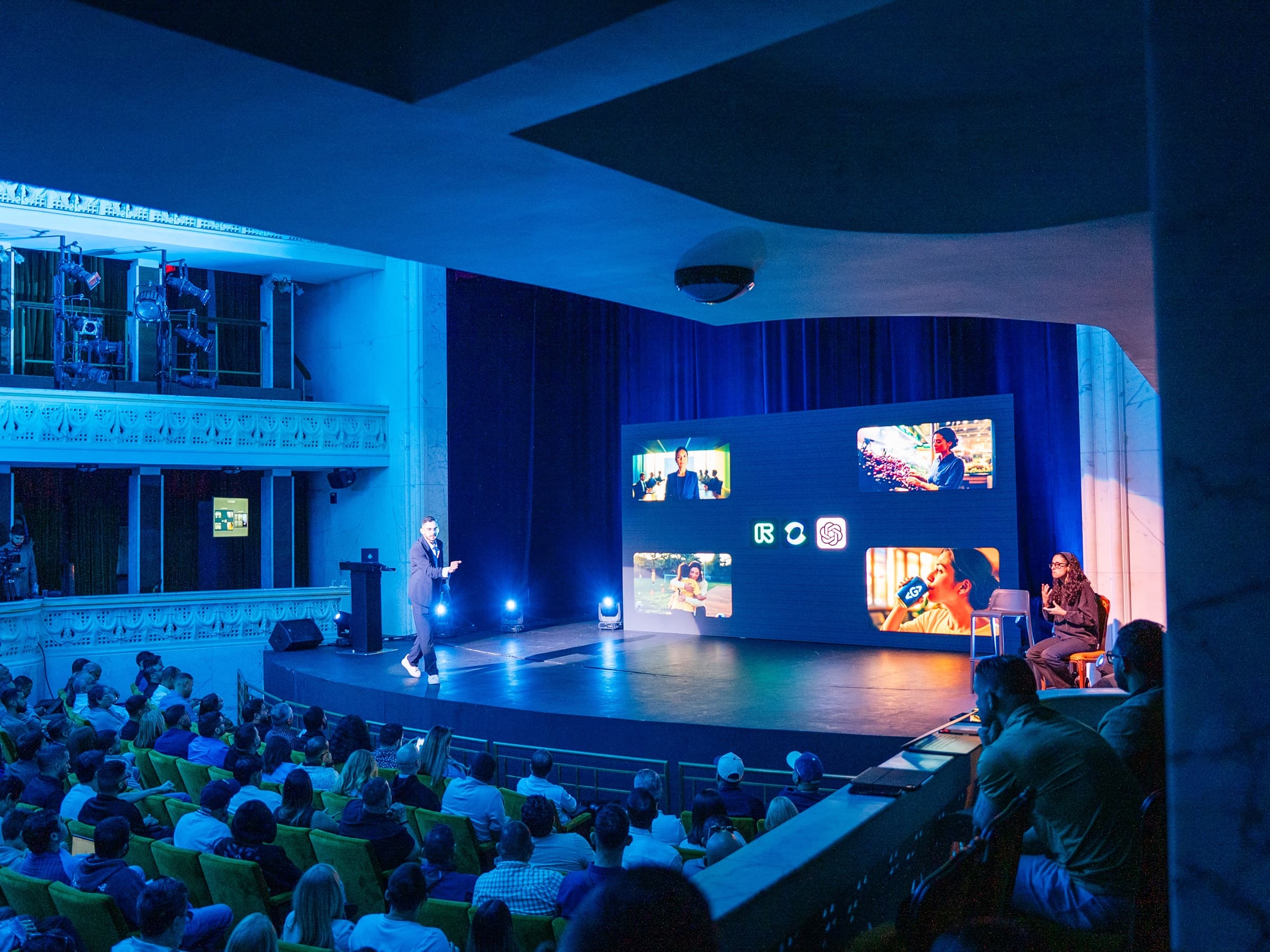 Joshua Castro presenting about AI to an audience in a theater
